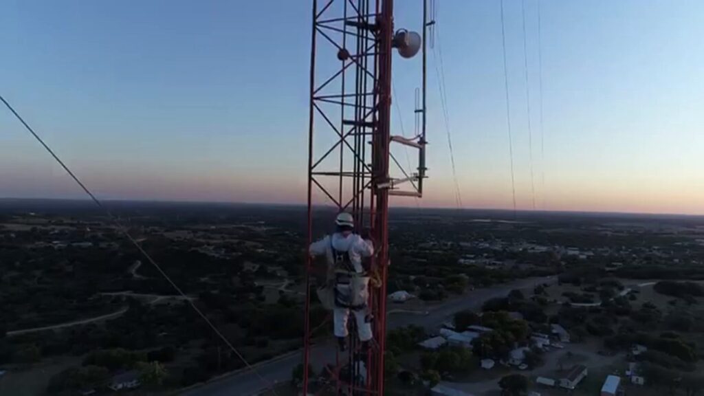 Communication tower showing alternating orange and white paint bands and white obstruction lights illustrating FAA tower painting requirements